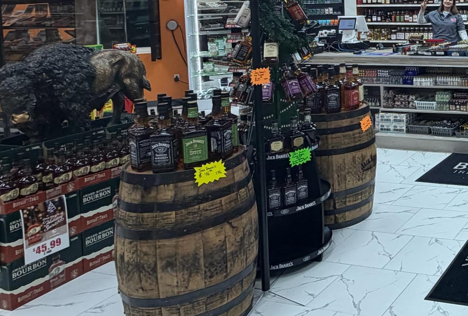 Bourbon bottles displayed on top of whiskey barrels on the marble floor