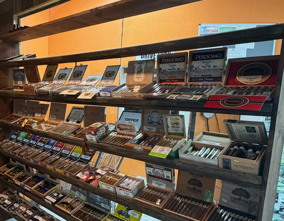 Open boxes of premium cigars on the tilted wooden shelves of the humidor